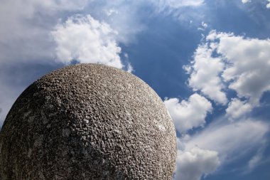 Gökyüzünün arka planında bulutlu büyük granit top 