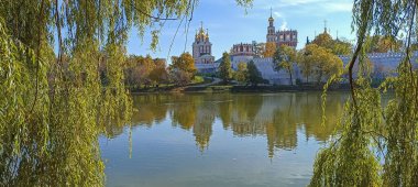 Novodevichy manastırı (Bogoroditse-Smolensky manastırı) ve güneşli bir sonbahar gününde büyük Novodevichy göleti manzarası (panoramik manzara). Moskova, Rusya. UNESCO dünya mirası sahası