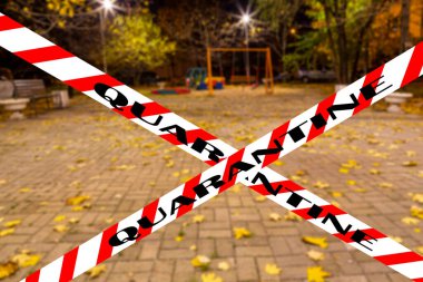 Moskova, Rusya 'da Coronavirus. Konut alanlarından birinde (bulanık manzara) bir sonbahar gecesinde boş bir oyun alanı. Karantina işareti. COVID salgını ve seyahat kavramı