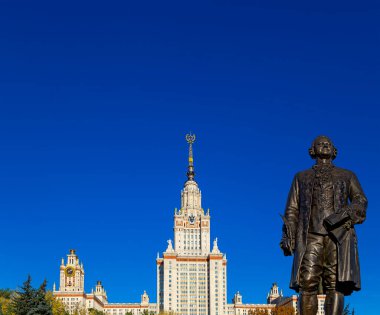 Rusya 'nın başkenti Sparrow Hills' teki Moskova Devlet Üniversitesi 'nin (MSU) ana binasının yanından Mikhail Vasilyevich Lomonosov anıtının (sonbahar güneşli günü) görüntüsü