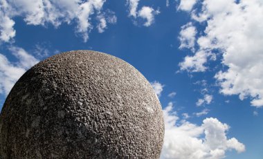 Gökyüzünün arka planında bulutlu büyük granit top 