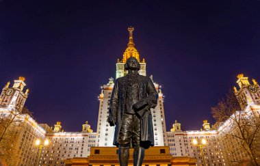 Rusya 'nın başkenti Sparrow Hills' teki Moskova Devlet Üniversitesi 'nin (MSU) ana binasının yanından Mikhail Vasilyevich Lomonosov anıtının (sonbahar akşamı) görüntüsü.  