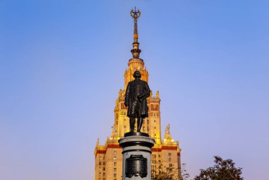 Rusya 'nın başkenti Sparrow Hills' teki Moskova Devlet Üniversitesi 'nin (MSU) ana binasının yanından Mikhail Vasilyevich Lomonosov anıtının (sonbahar akşamı) görüntüsü.  