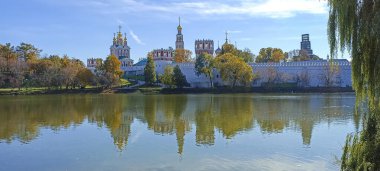 Novodevichy manastırı (Bogoroditse-Smolensky manastırı) ve güneşli bir sonbahar gününde büyük Novodevichy göleti manzarası (panoramik manzara). Moskova, Rusya. UNESCO dünya mirası sahası