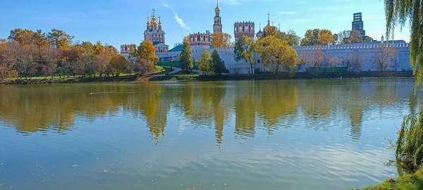 Novodevichy manastırı (Bogoroditse-Smolensky manastırı) ve güneşli bir sonbahar gününde büyük Novodevichy göleti manzarası (panoramik manzara). Moskova, Rusya. UNESCO dünya mirası sahası