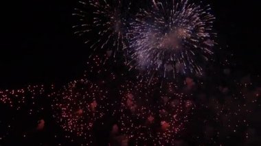 Voleler gece gökyüzünde milyonlarca ışığı böler. Canlı renkli havai fişek gösterisi. Gece gökyüzünde havai fişekler 
