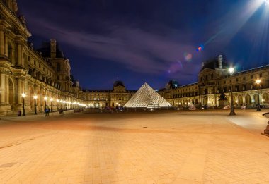 Paris, Fransa - Mayıs 08, 2019: Louvre Sarayı ve Piramit (1989 yılında tamamlandı), (gece). Louvre, Paris 'teki en büyük müze. 60.000 metrekareden fazla sergi alanı var. 