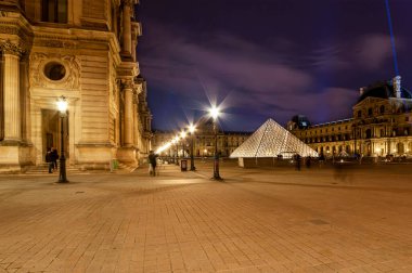 Paris, Fransa - Mayıs 08, 2019: Louvre Sarayı ve Piramit (1989 yılında tamamlandı), (gece). Louvre, Paris 'teki en büyük müze. 60.000 metrekareden fazla sergi alanı var. 
