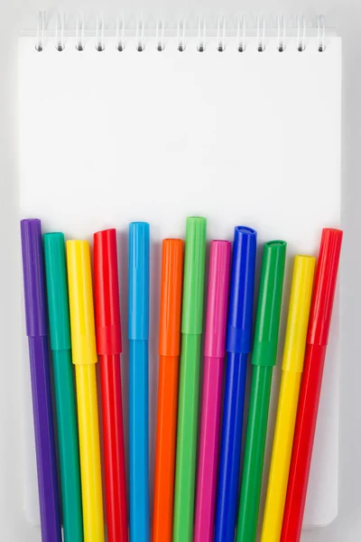 Colored marker pens on a white notepad — Stock Photo, Image