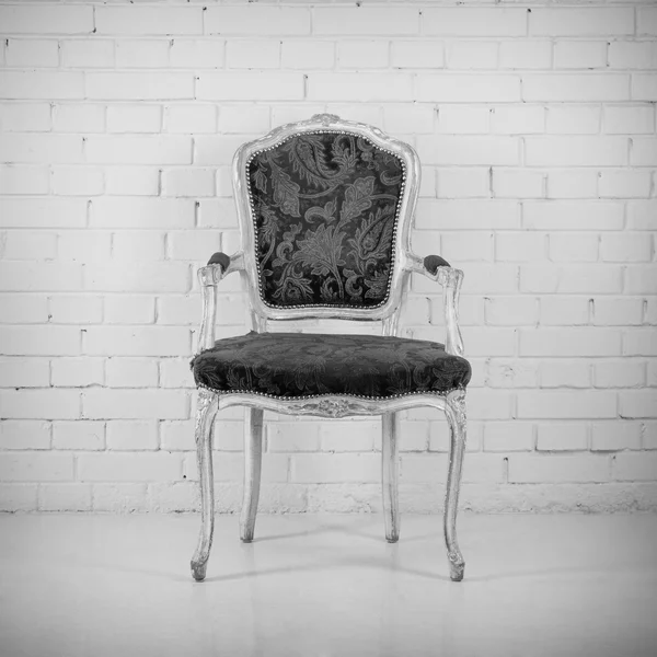 Vintage chair against white brick wall with clock — Stock Photo
