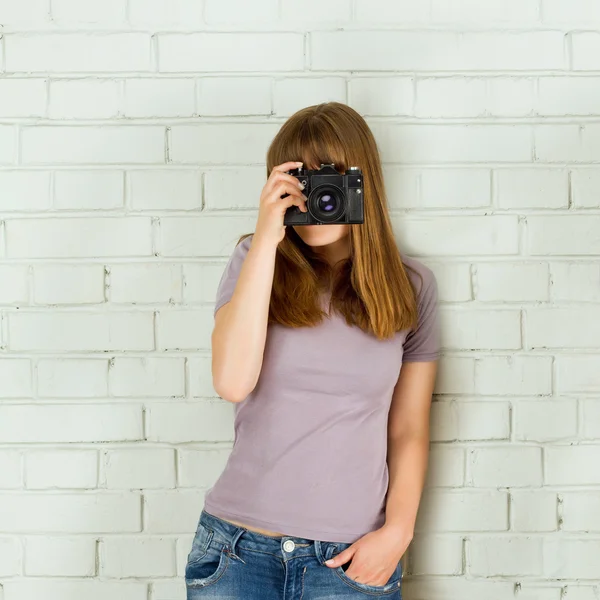 Chica joven tomando fotos con una vieja cámara vintage — Foto de Stock