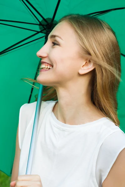 Yeşil şemsiye tutan mutlu gülümseyen kız — Stok fotoğraf