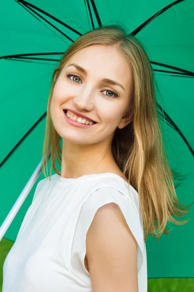 Young smiling girl holding a green umbrella — Stock Photo, Image