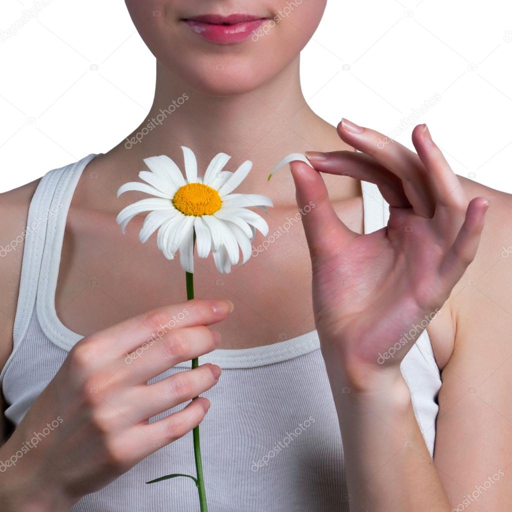 Young girl guesses on a chamomile flower