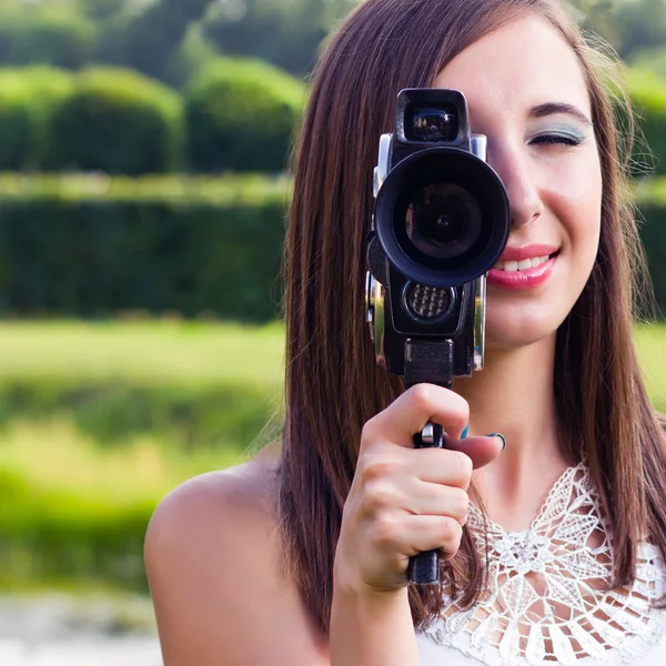 Chica joven usando una cámara antigua — Foto de Stock