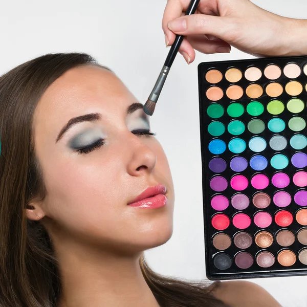 Young woman at beauty salon. Applying eye shadows