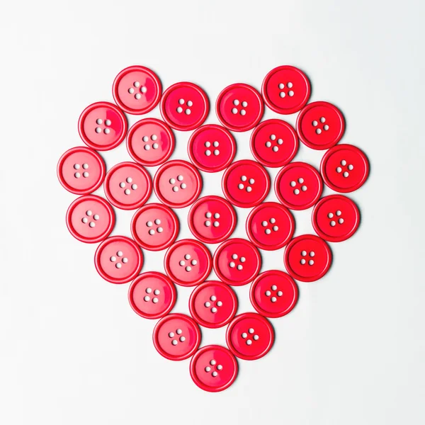 Red sewing buttons arranged in a heart shape — Stock Photo, Image