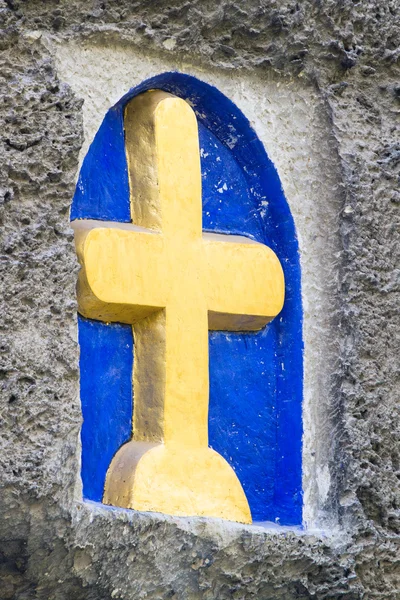 Gelbes Kreuz auf Steinmauer. — Stockfoto