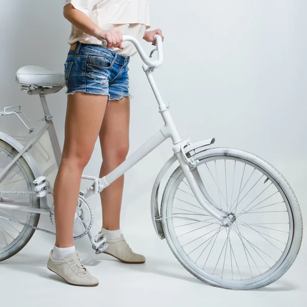 Молодая девушка на белом винтажном велосипеде — стоковое фото