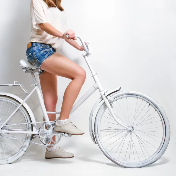 Jovem mulher montando uma bicicleta vintage branca — Fotografia de Stock