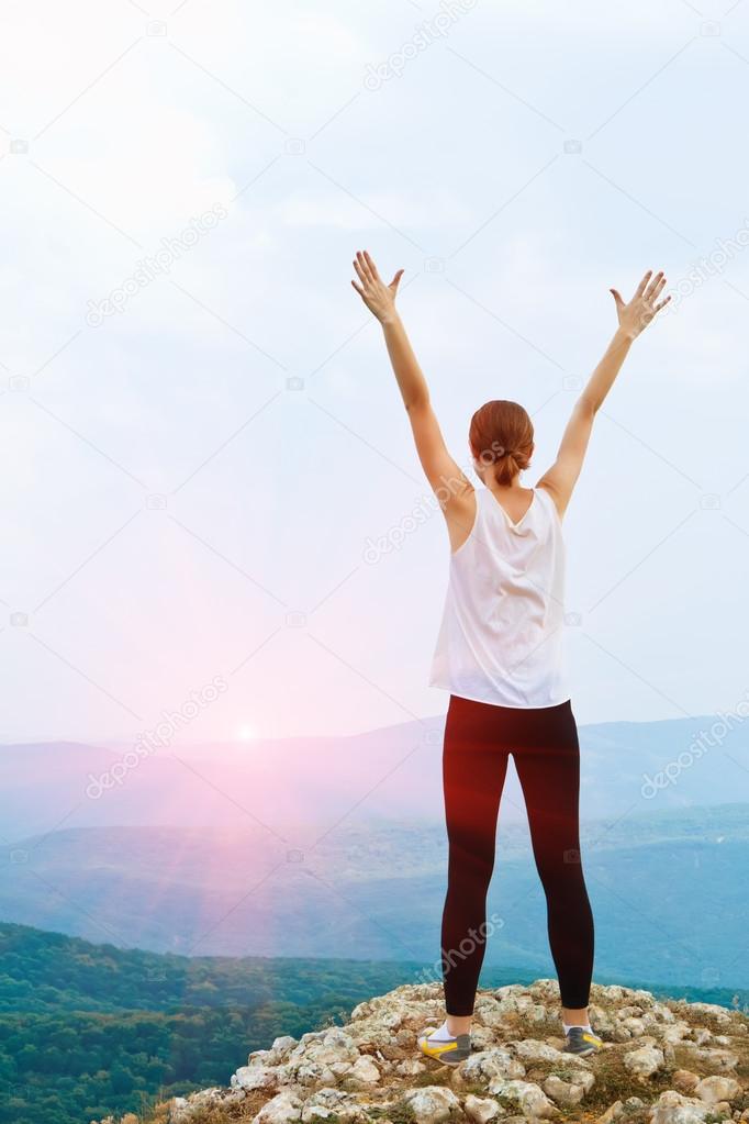 Happy young woman with arms raised