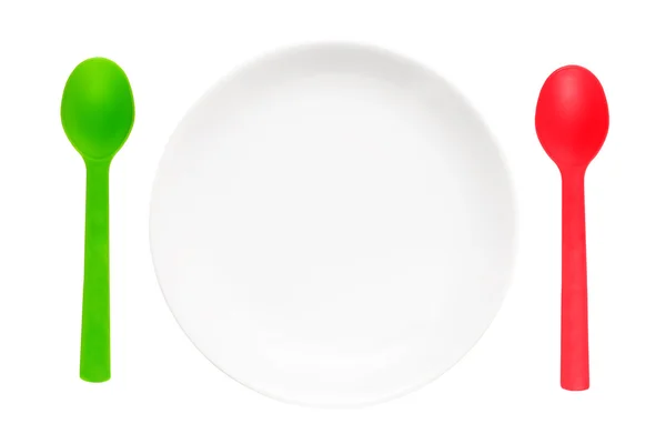 White plate with red and green spoons — Stock Photo, Image
