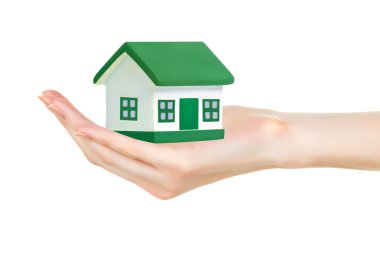 Beyaz arka plan üzerinde izole elinde yeşil ev