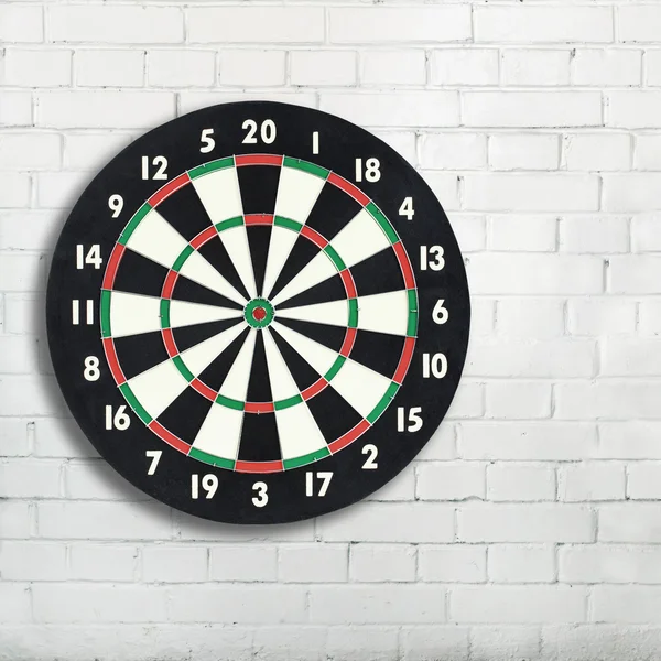 Darts board on a white brick wall with copy space — Stock Photo, Image