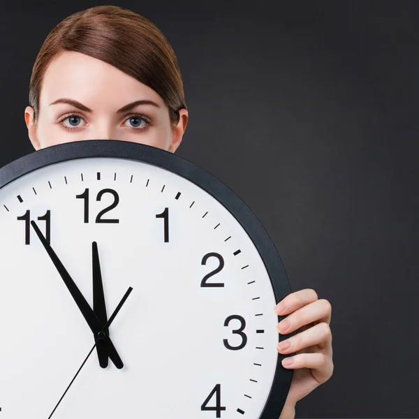 Mujer joven sosteniendo un gran reloj —  Fotos de Stock