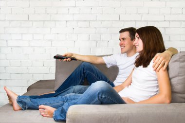 genç bir çift TV izliyor. çift kanepe TV uzaktan. 