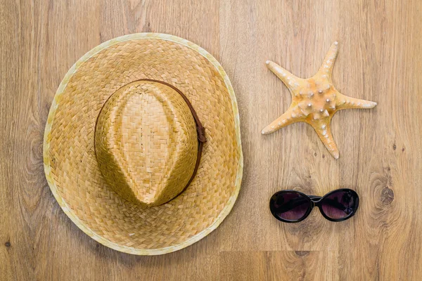Chapéu trançado, estrela do mar e óculos — Fotografia de Stock