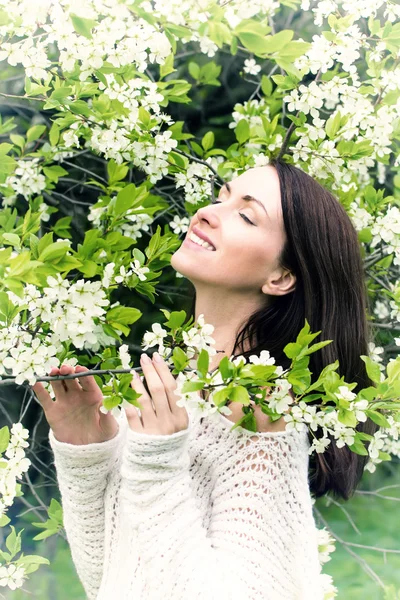 Vrouw enjoing witte bloesem bloemen — Stockfoto