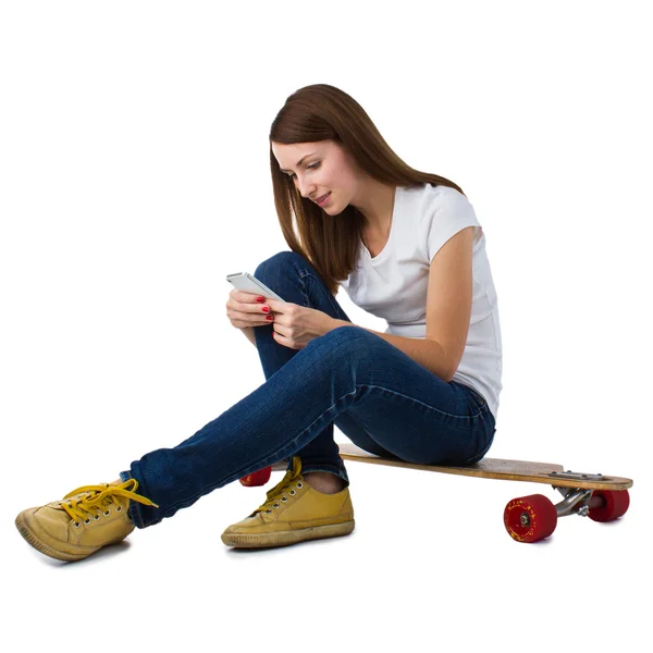 Žena sedí na skateboard s Kobaltová modř telefon — Stock fotografie
