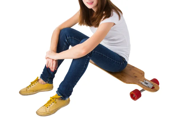 Young woman sitting on a skateboard — Stock Photo, Image