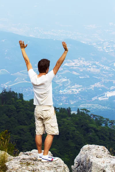 Junger Mann steht auf einer Klippe — Stockfoto