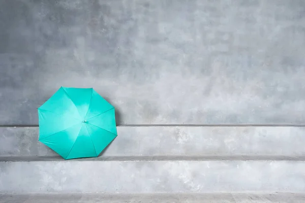 Green umbrella on concrete stairs with blank space on the wall background — Stock Photo, Image