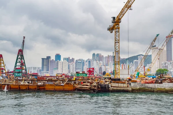 HONG KONG - 23 AĞUSTOS 2012: bulutlu gökyüzüne karşı Victoria Limanı 'nda inşaat alanı. Hong Kong 'da yapay adalar inşa ediyor.