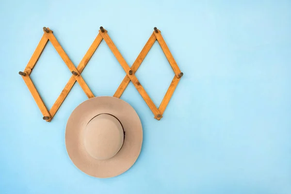 Wandanhänger aus Holz mit beigem Wildlederhut gegen blaue Wand. auf blauem Hintergrund. Minimales, trendiges Home-Detail — Stockfoto