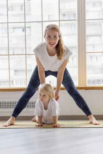 Junge glückliche Mutter macht Fitnessübungen mit 3-jährigem Mädchen — Stockfoto