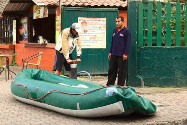 Inflating a Rubber Boat in Banos, Ecuador clipart