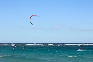 BOCA GRANDI, ARUBA - 17 Aralık 2020: Kite ve kanat sörfçüleri San Nicolas kasabası yakınlarındaki Karayip adası Aruba 'nın güneydoğu sahilinde Boca Grandi plajında (Seçici Odaklanma, sörfçülere odaklan))