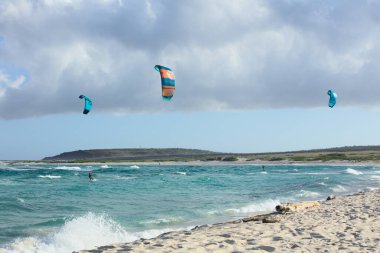 BOCA GRANDI, ARUBA - 17 Aralık 2020: San Nicolas kasabası yakınlarındaki Karayip adası Aruba 'nın güneydoğu sahilindeki Boca Grandi plajındaki uçurtmacılar (Seçici Odak, Sörfçülere Odaklan))
