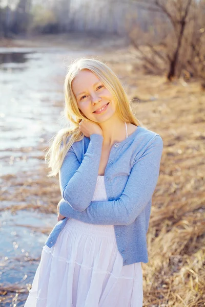 Lachende blond meisje buiten in het bos in de buurt van de rivier — Stockfoto
