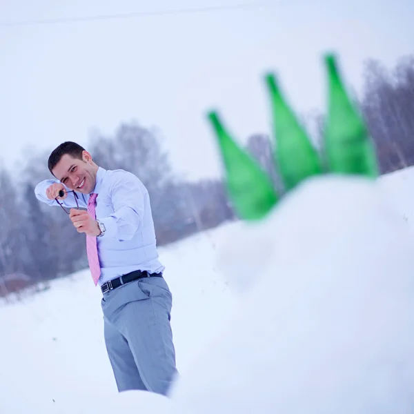 Businessman in winter forest with slingshot — Stock Photo, Image