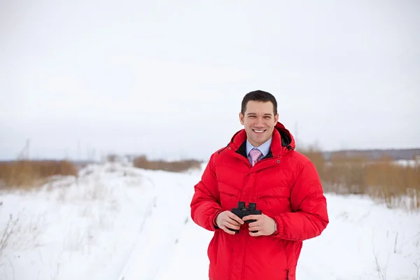 Business man with binocular in winter field — Stock Photo, Image
