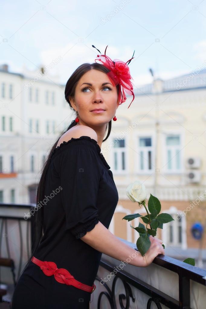 Pretty girl with flower on balcony outdoor