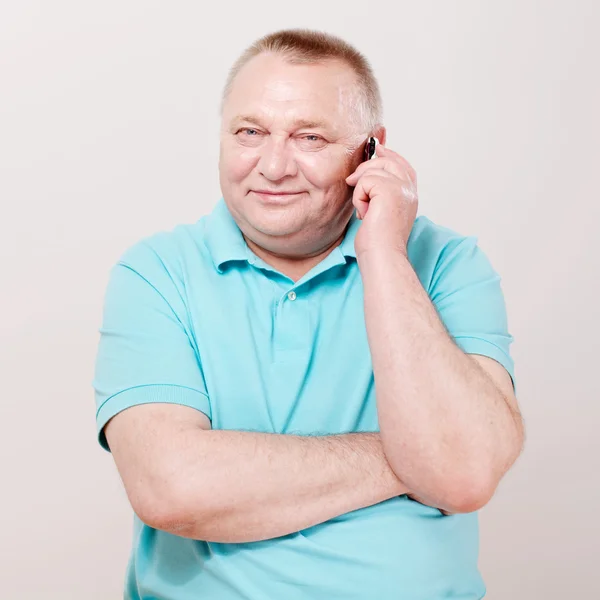 Homem sênior com telefone sobre branco — Fotografia de Stock