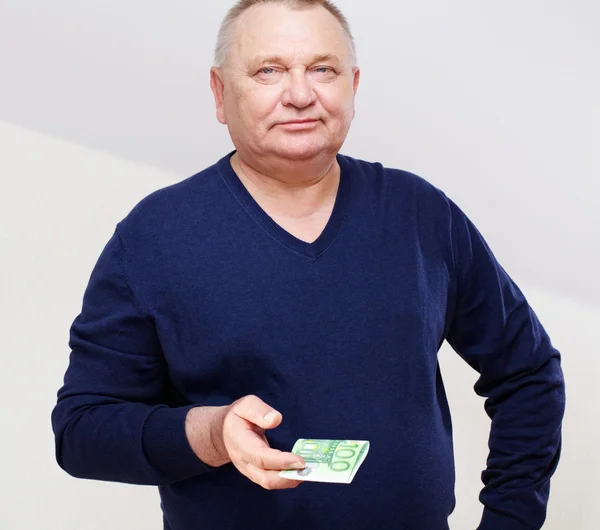 Paying senior man in jumper over white — Stock Photo, Image