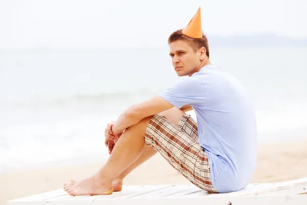 Man in feest hoed op strand — Stockfoto