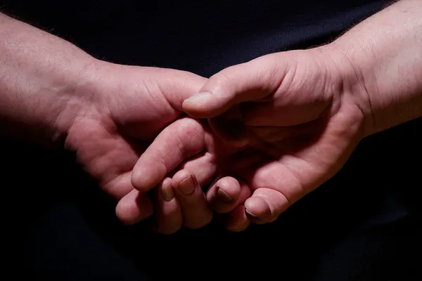 Hands behind back closeup over black — Stock Photo, Image